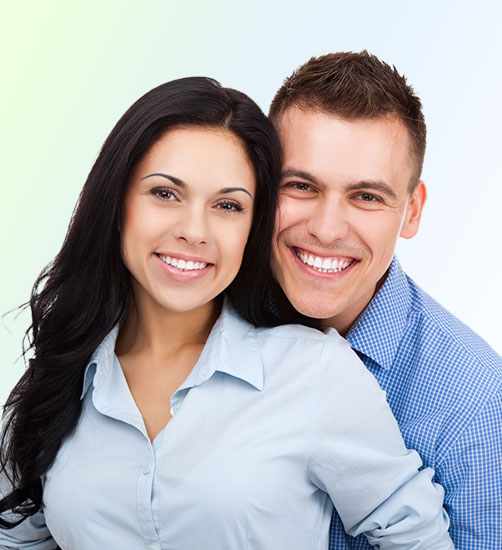 Happy couple smiling brightly with whiter teeth after professional teeth whitening and bleaching treatment.