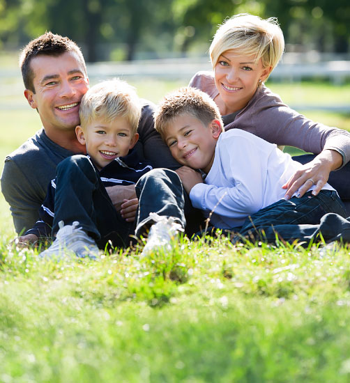 Happy family smiling confidently with straight teeth after completing Invisalign treatment.