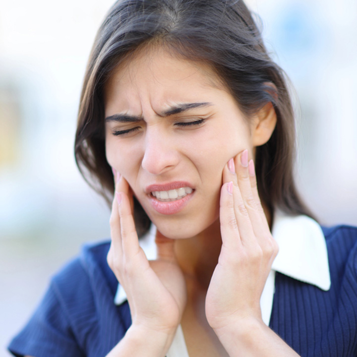 Woman experiencing chronic jaw pain before receiving treatment