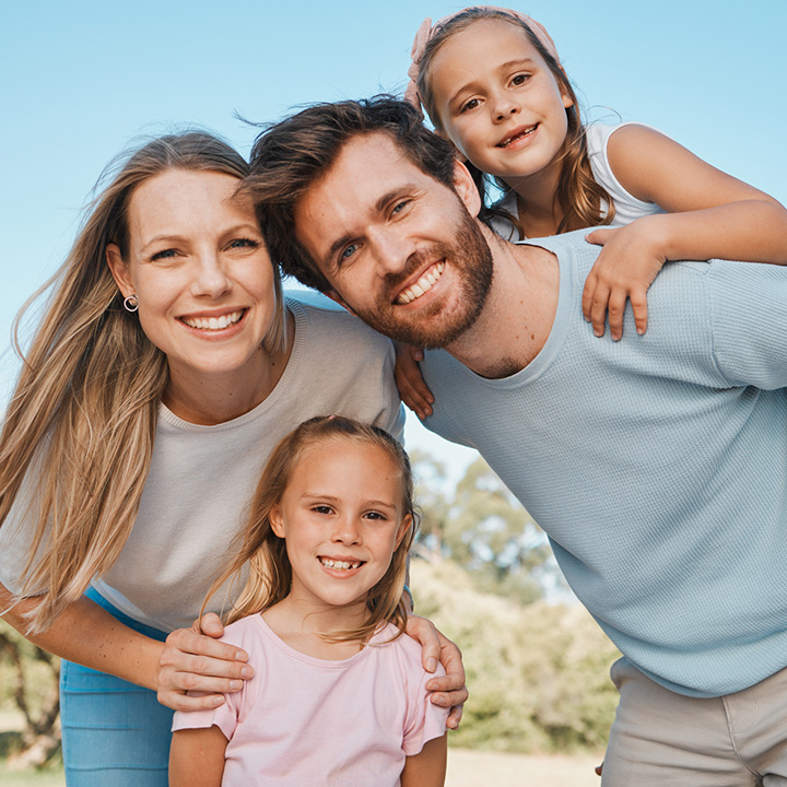 Happy family showing bright smiles after whitening treatment in Stafford, VA